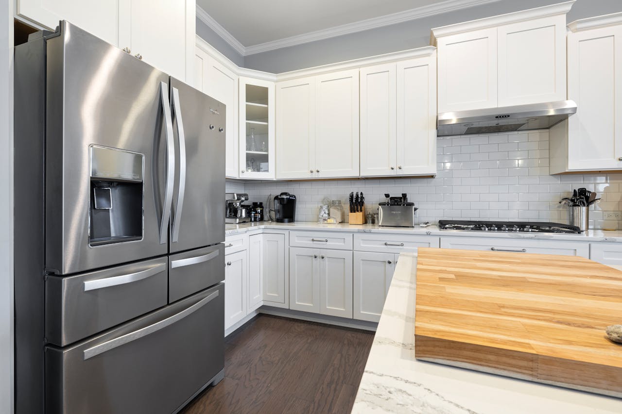Spacious modern kitchen featuring stainless steel appliances and white cabinets, perfect for culinary enthusiasts.